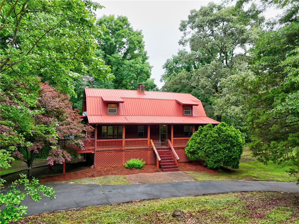 237 Spring Valley Road Liberty, SC 29657 - Photo 29 of 50 A charming cabin-style home with a vibrant red metal roof nestles among mature trees.