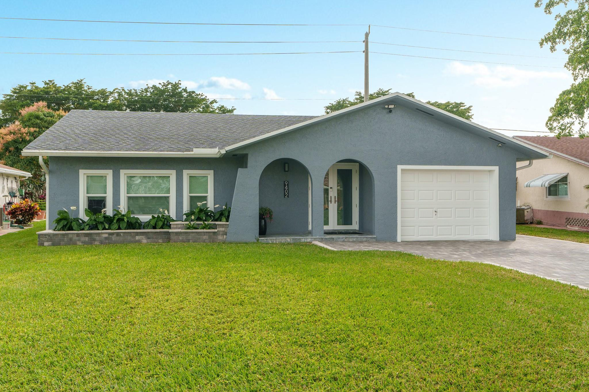9402 Northwest 70th Street Tamarac, FL 33321 - Photo 1 of 60 a view of a house with a yard and garage