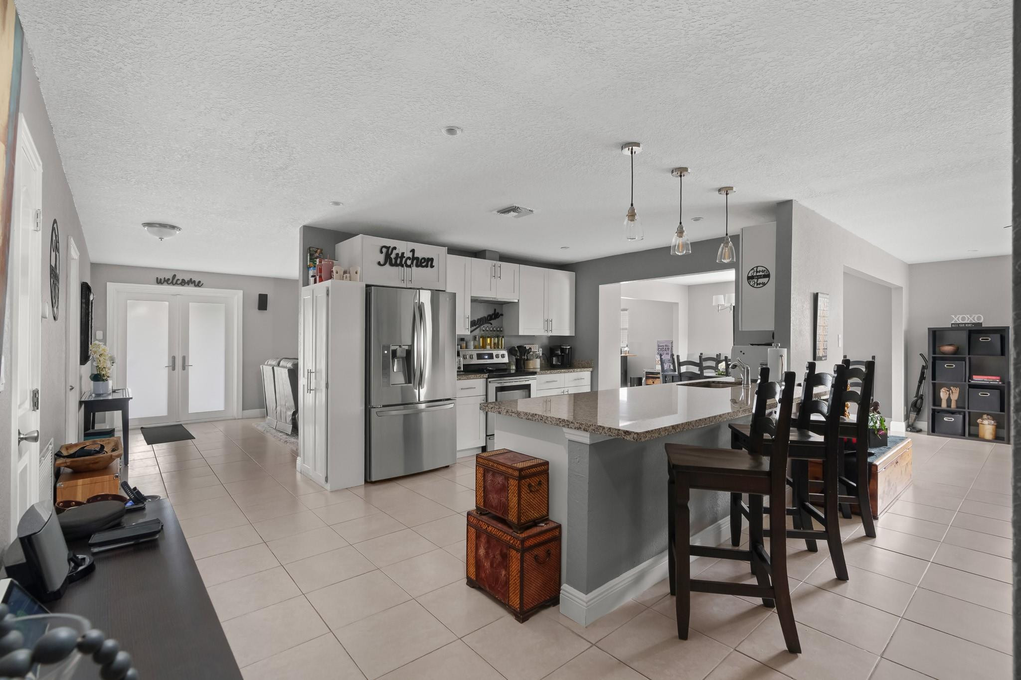 9402 Northwest 70th Street Tamarac, FL 33321 - Photo 14 of 60 a kitchen with stainless steel appliances kitchen island granite countertop a refrigerator and cabinets