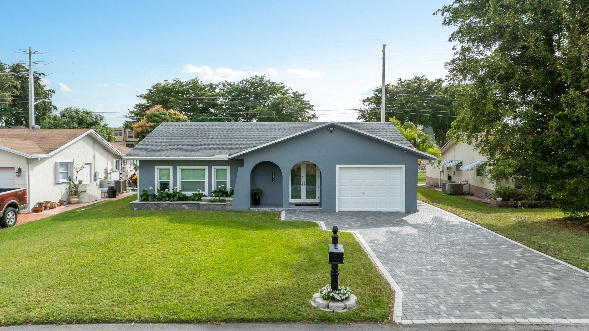 9402 Northwest 70th Street Tamarac, FL 33321 - Photo 2 of 60 a house view with a garden space