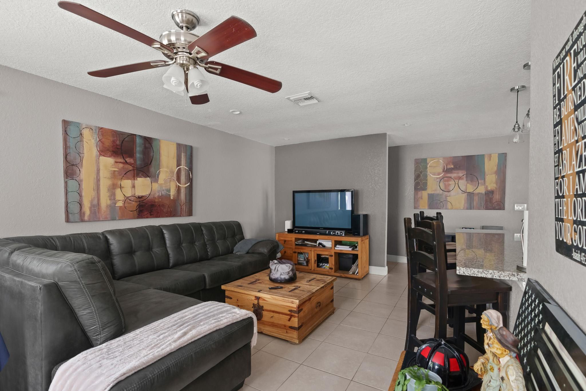 9402 Northwest 70th Street Tamarac, FL 33321 - Photo 23 of 60 a living room with furniture and a flat screen tv