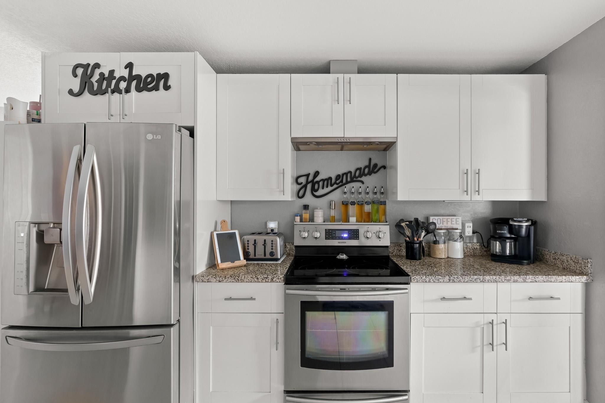 9402 Northwest 70th Street Tamarac, FL 33321 - Photo 26 of 60 a kitchen with a refrigerator stove and white cabinets