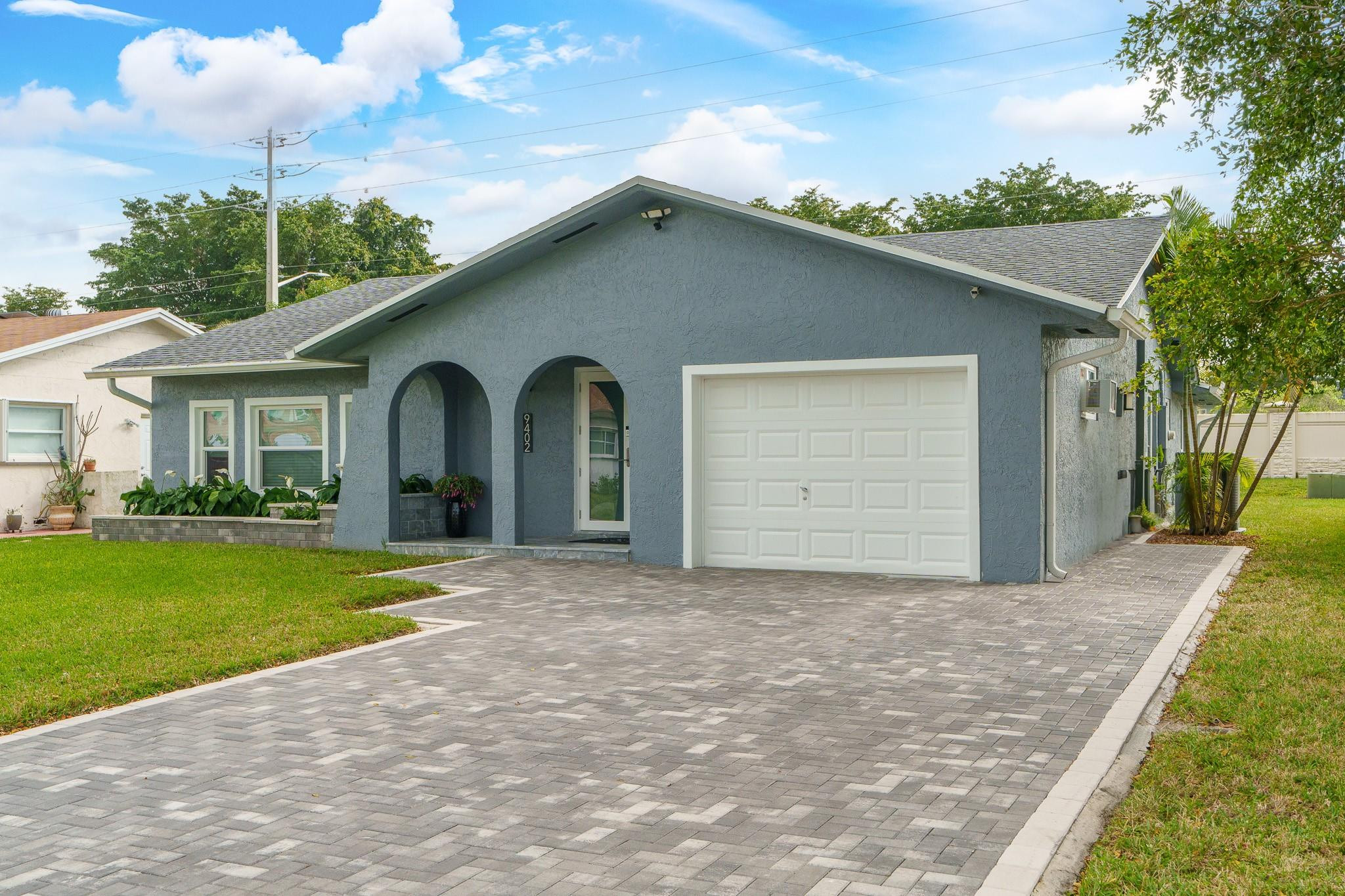 9402 Northwest 70th Street Tamarac, FL 33321 - Photo 3 of 60 a view of a house with a yard and garage