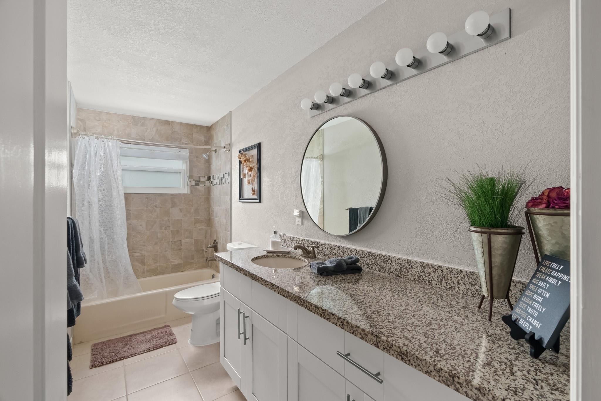 9402 Northwest 70th Street Tamarac, FL 33321 - Photo 43 of 60 a bathroom with a granite countertop sink a toilet and a mirror