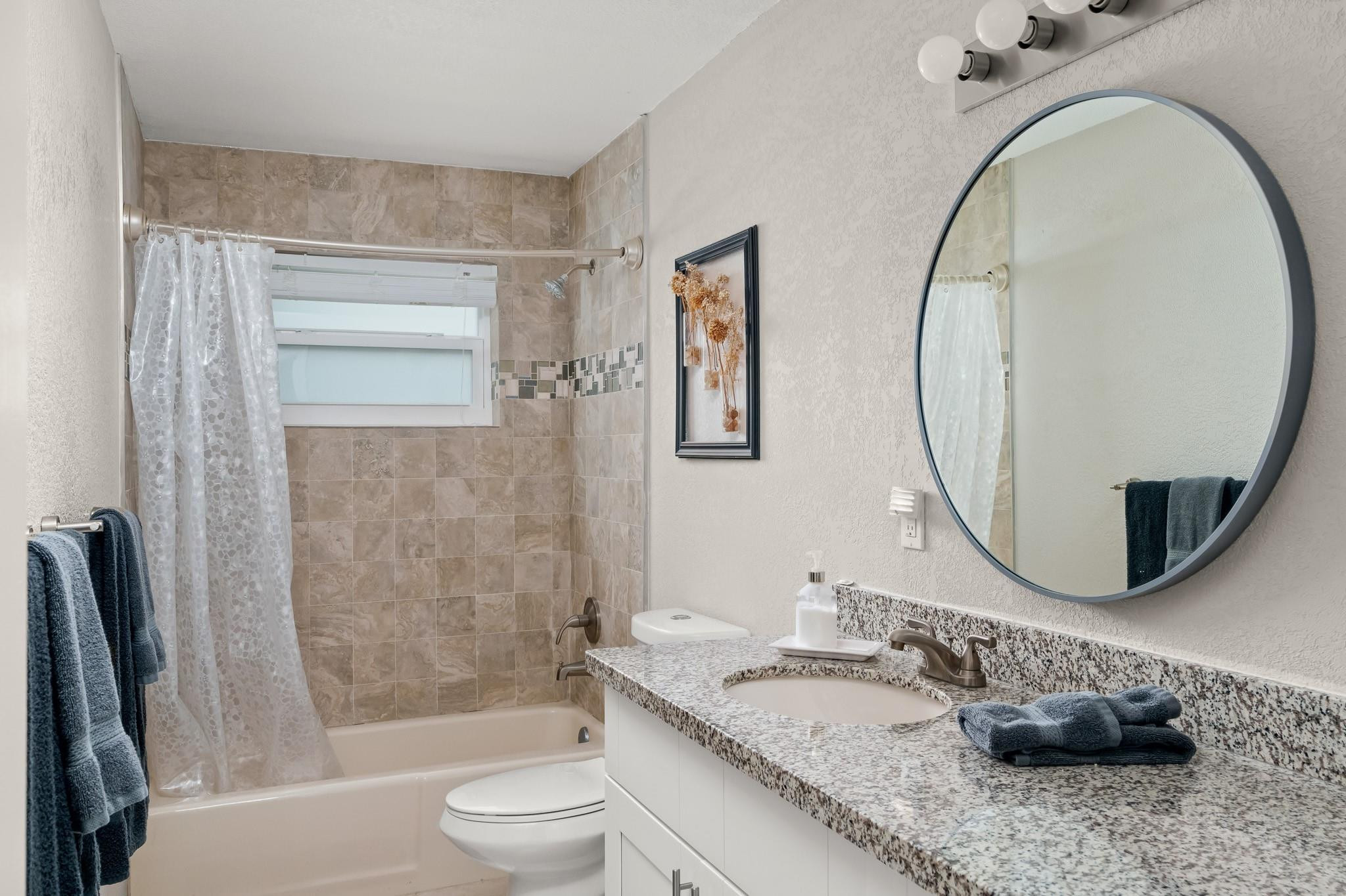 9402 Northwest 70th Street Tamarac, FL 33321 - Photo 44 of 60 a bathroom with a granite countertop sink a toilet and a mirror