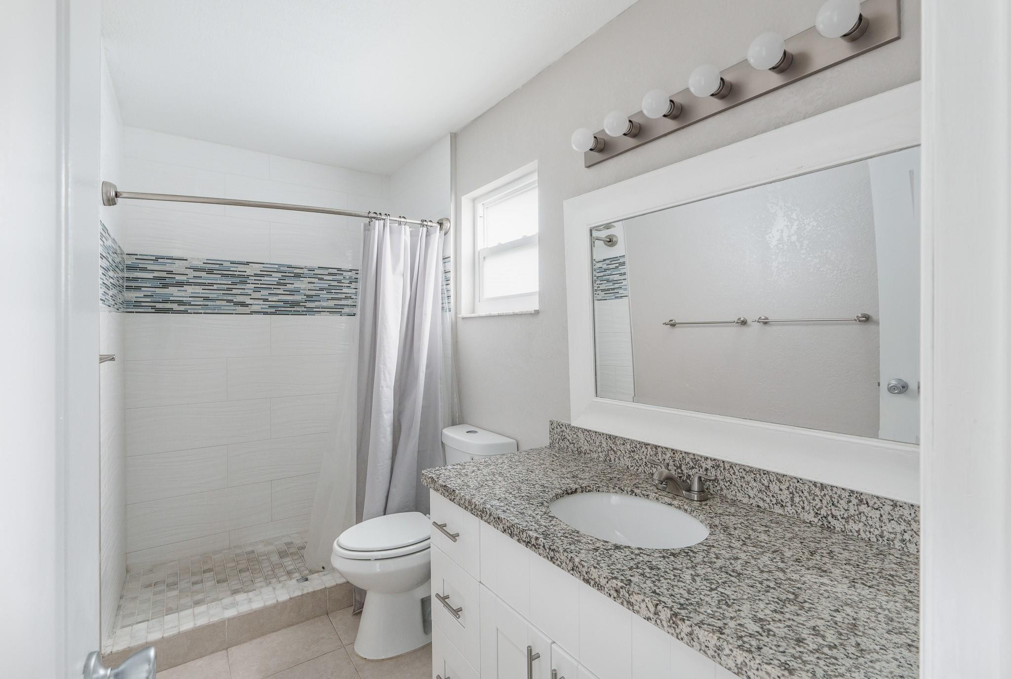 9402 Northwest 70th Street Tamarac, FL 33321 - Photo 45 of 60 a bathroom with a granite countertop sink toilet and shower
