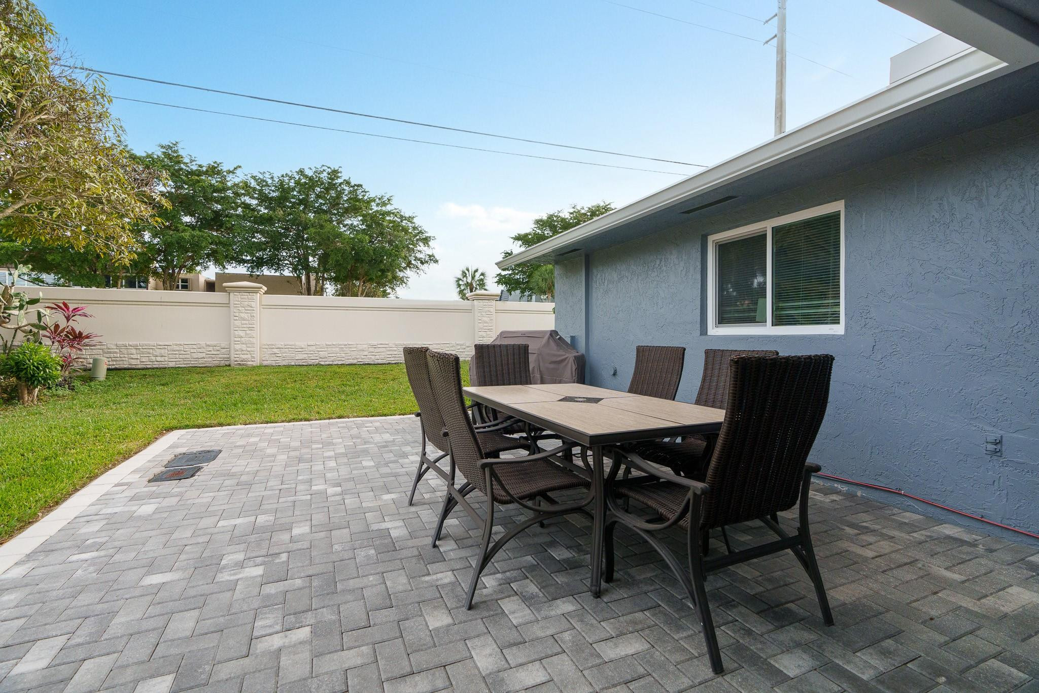9402 Northwest 70th Street Tamarac, FL 33321 - Photo 46 of 60 a backyard of a house with table and chairs