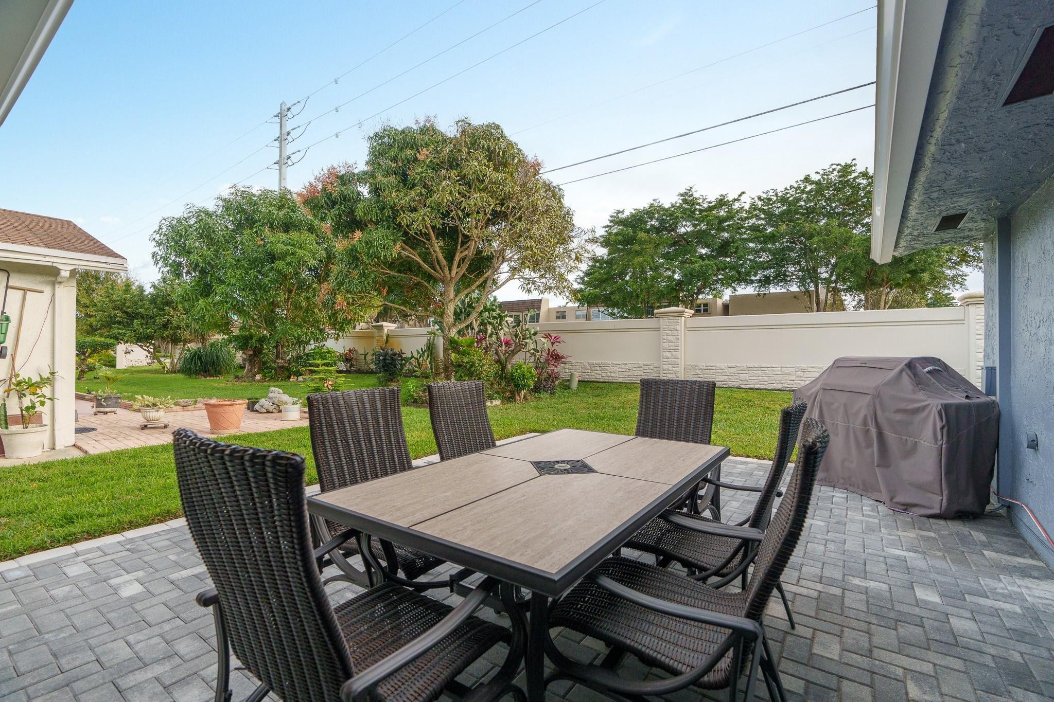 9402 Northwest 70th Street Tamarac, FL 33321 - Photo 47 of 60 a view of an outdoor dining space with a table and chairs