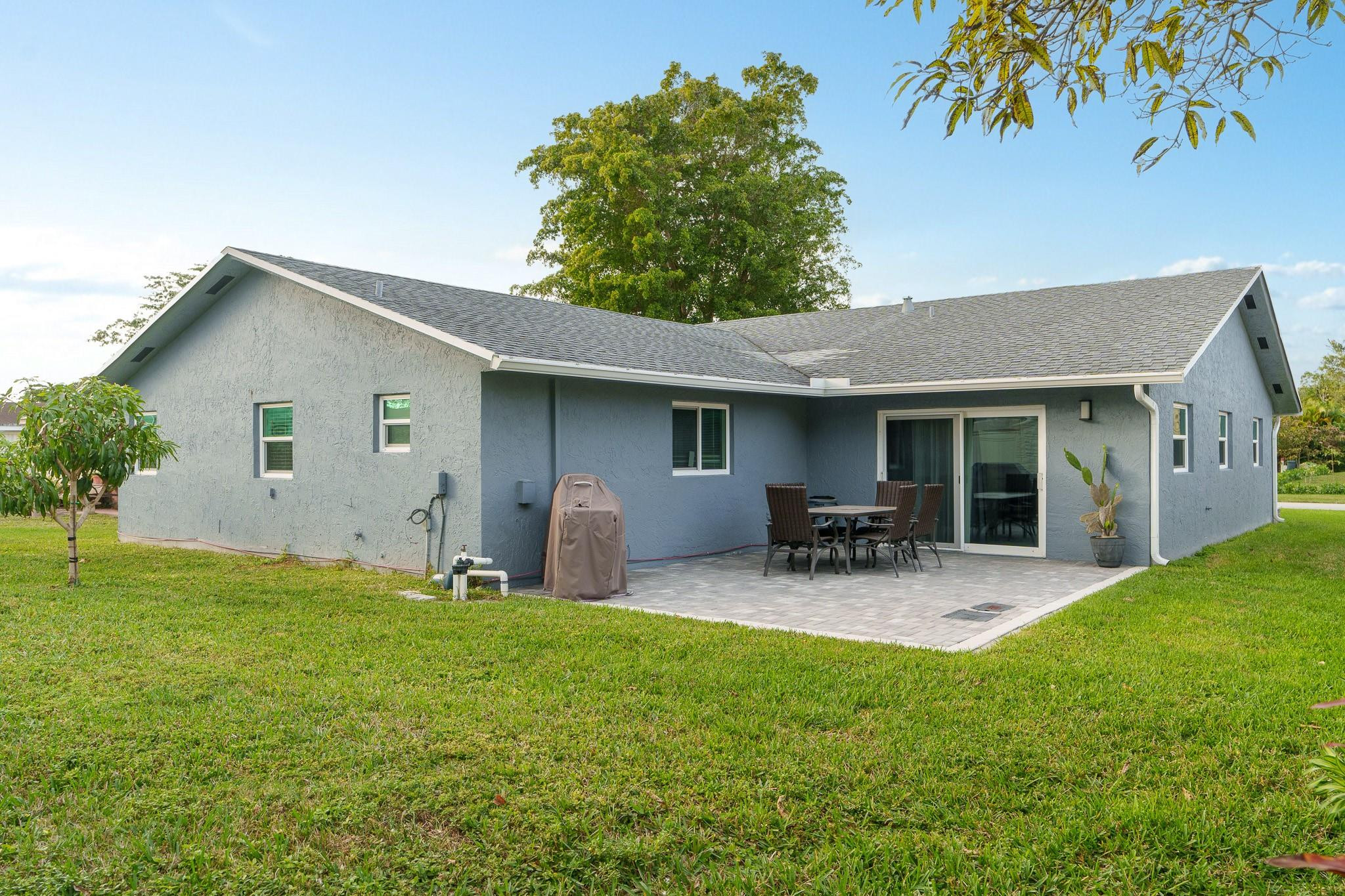 9402 Northwest 70th Street Tamarac, FL 33321 - Photo 50 of 60 a backyard of a house with table and chairs