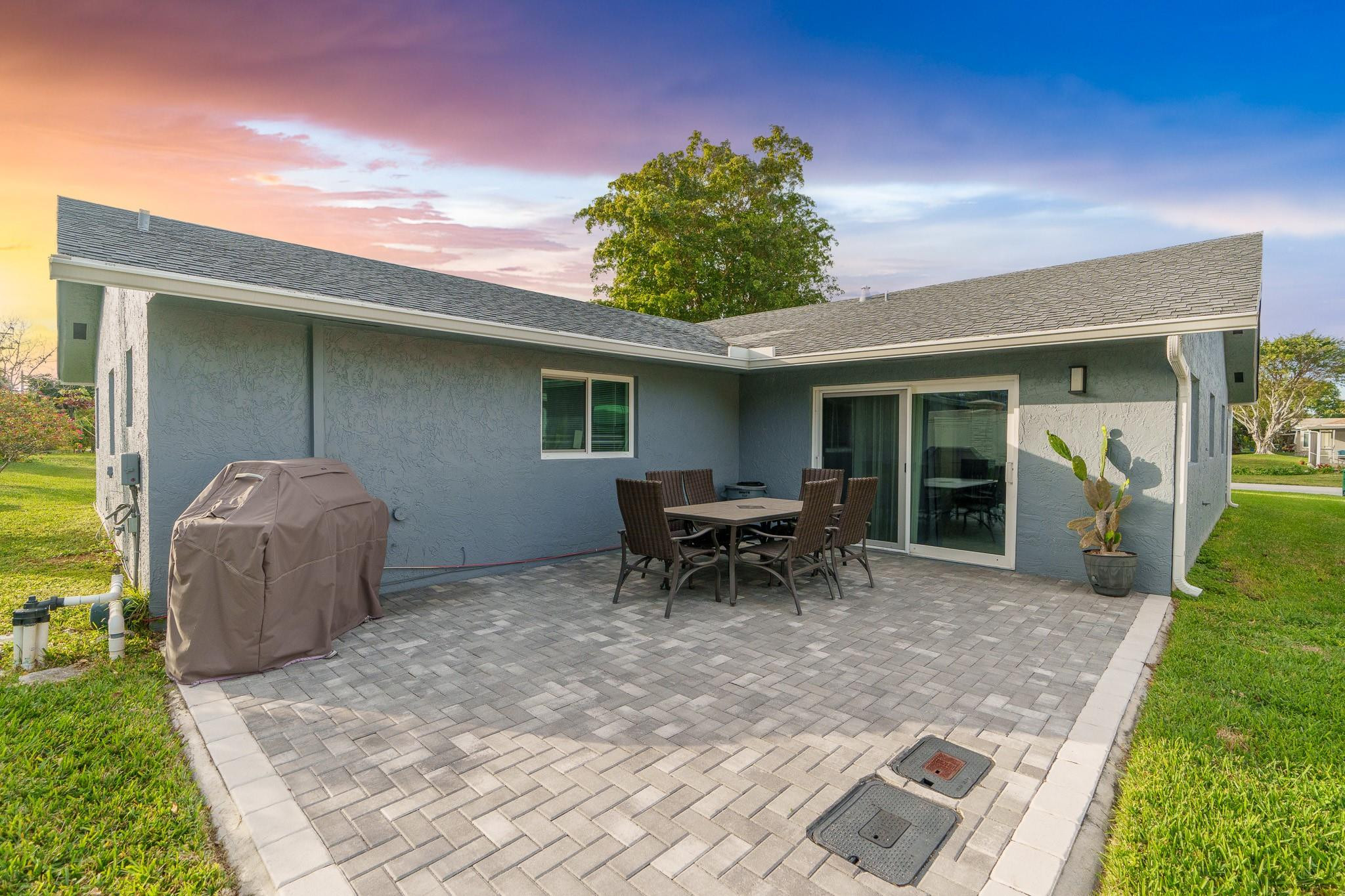 9402 Northwest 70th Street Tamarac, FL 33321 - Photo 51 of 60 a backyard of a house with table and chairs