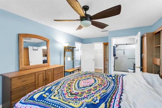 a bedroom with a bed and a large mirror on the dresser