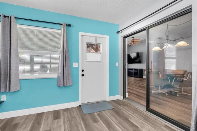 a view of a room with wooden floor and a potted plant