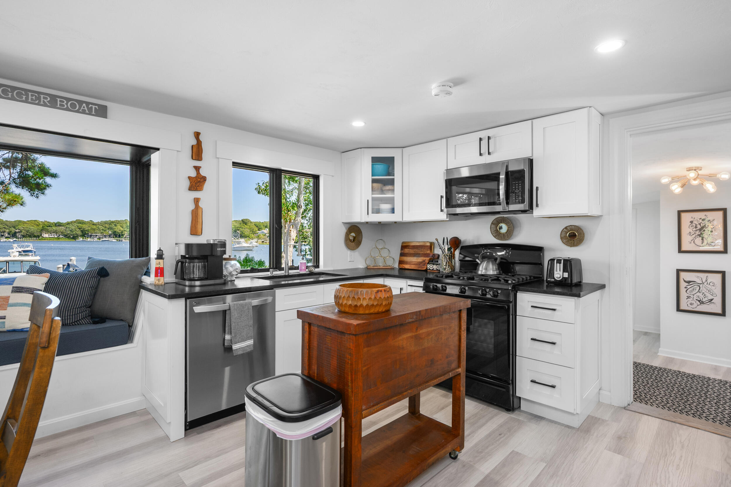 18 Great River Road Mashpee, MA 02649 - Photo 17 of 99 a kitchen with stainless steel appliances granite countertop a stove top oven a sink dishwasher a dining table and chairs with wooden floor