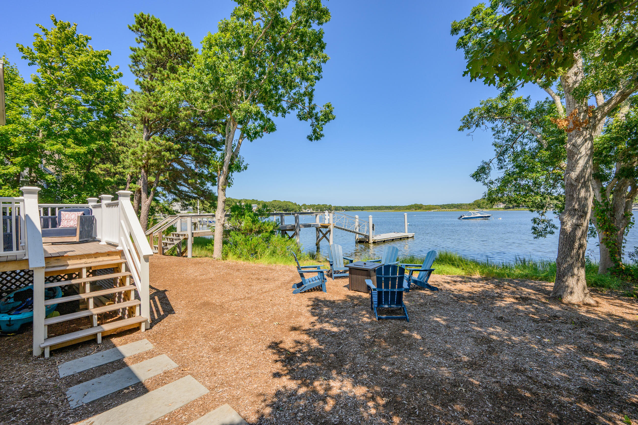 18 Great River Road Mashpee, MA 02649 - Photo 60 of 99 a view of a patio with table and chairs with a barbeque grill and a small yard