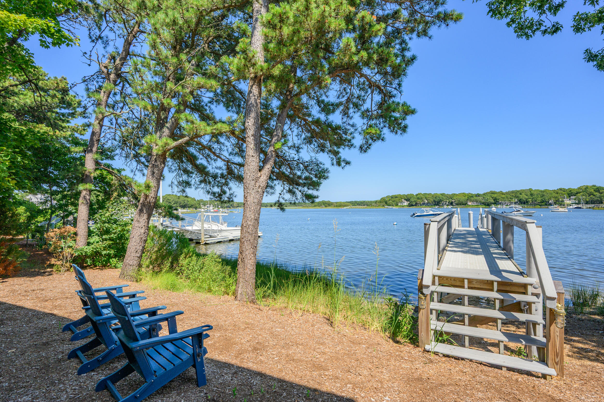 18 Great River Road Mashpee, MA 02649 - Photo 70 of 99 a view of a patio with table and chairs with wooden floor and fence