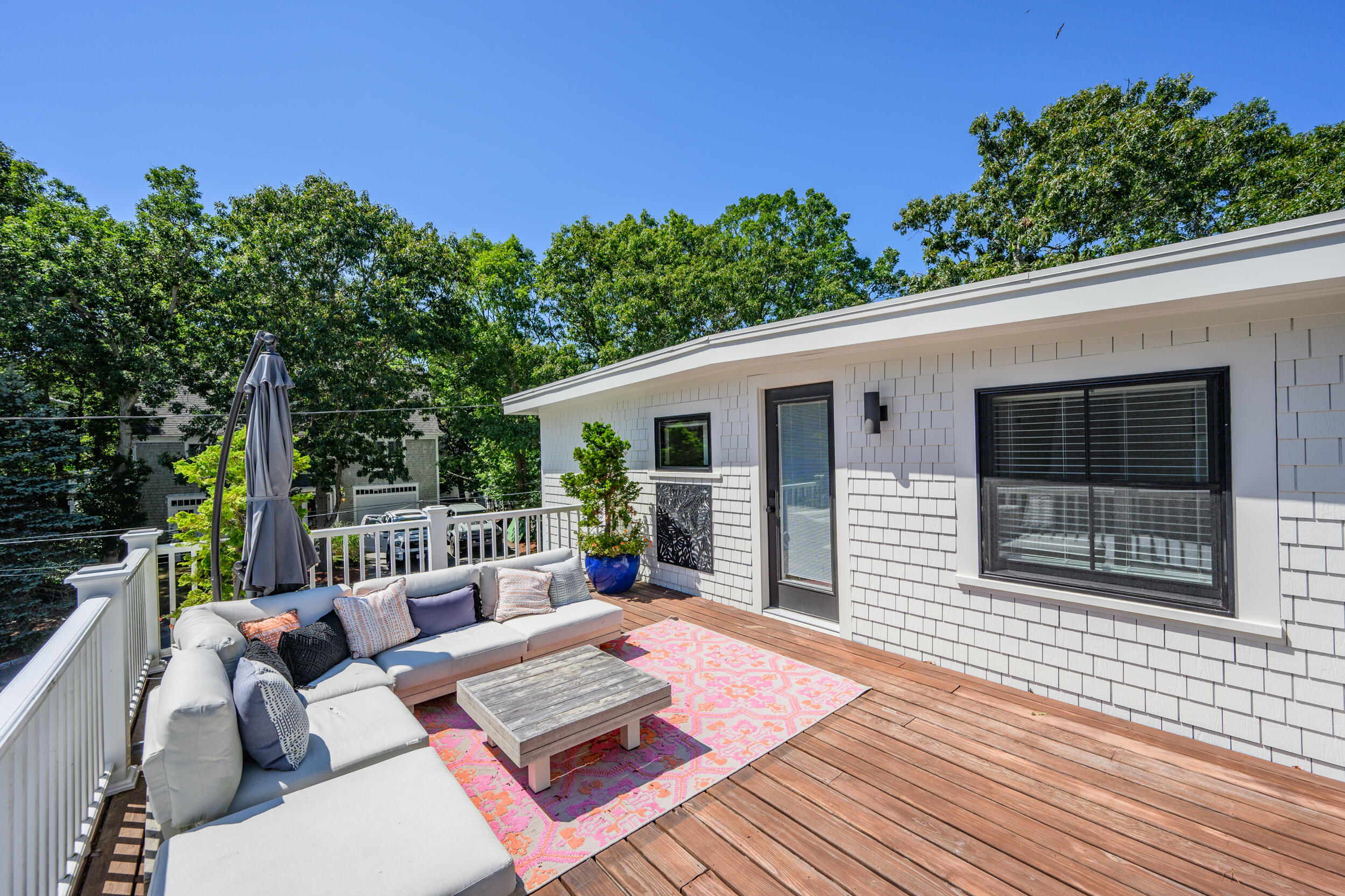 18 Great River Road Mashpee, MA 02649 - Photo 83 of 99 a view of a patio with couches and table and chairs with wooden floor and fence