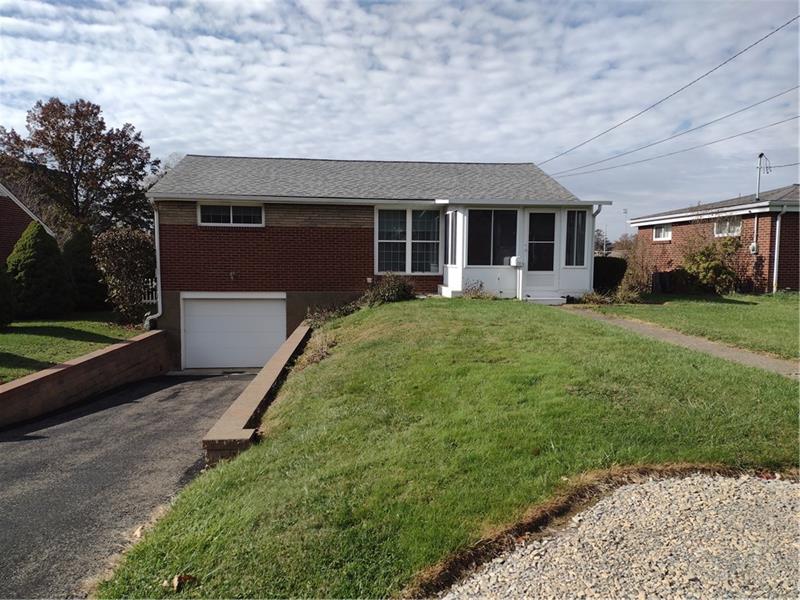 a front view of a house with a garden and yard