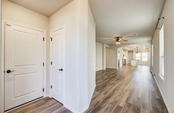 a view of a hallway with wooden floor and staircase