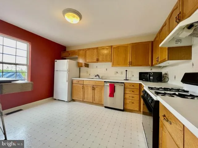 a kitchen with granite countertop a sink stainless steel appliances and cabinets