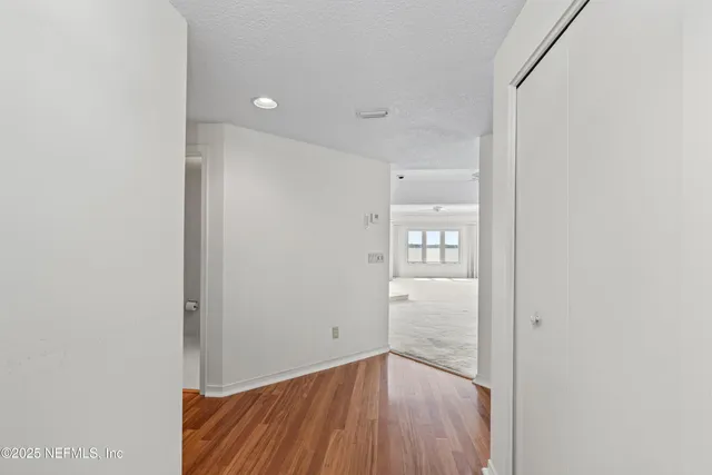 a view of a hallway with wooden floor