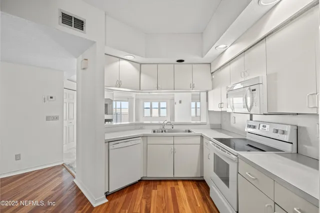 a kitchen with a sink cabinets stainless steel appliances and a window