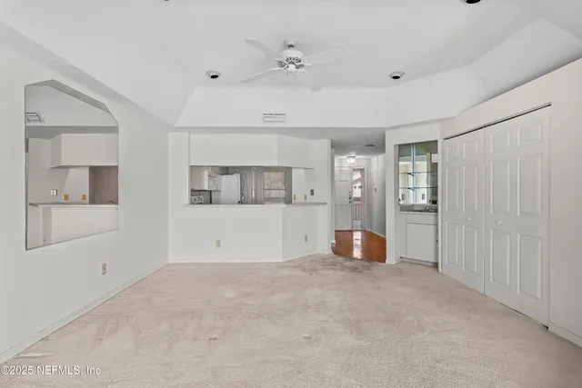 a view of an empty room with wooden floor and windows
