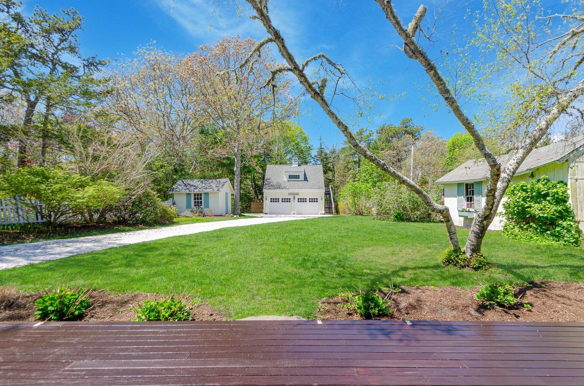 1089 Main Street Cotuit, MA 02635 - Photo 26 of 41 a view of a yard with plants and a bench