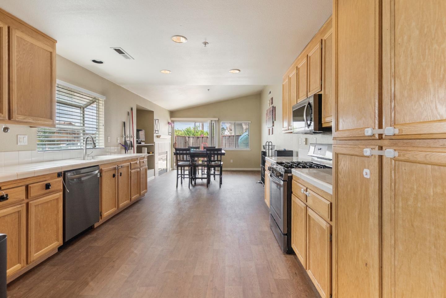 1001 Eagle Drive Salinas, CA 93905 - Photo 9 of 39 a kitchen with stainless steel appliances granite countertop a stove top oven a sink a dining table and chairs