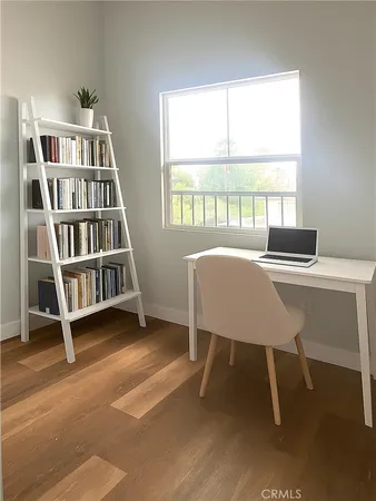 a view of a workspace with furniture and a window