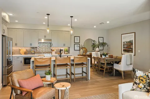 a living room with lots of furniture and kitchen view