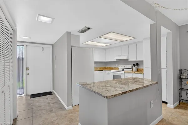 a kitchen with granite countertop a sink and a refrigerator