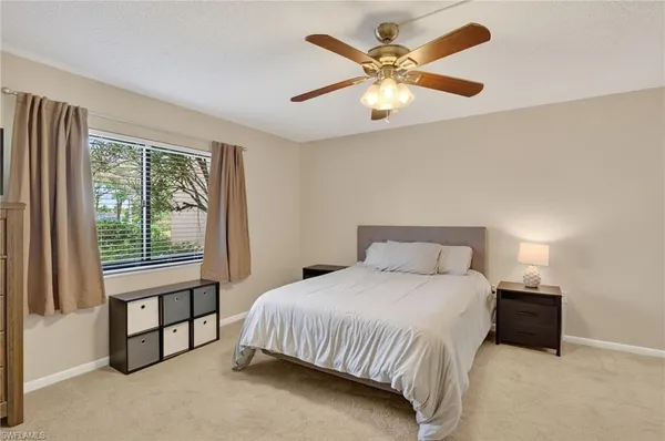 a bedroom with a bed chandelier and a window