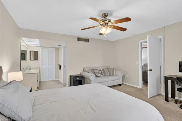 a bedroom with a large bed and a chandelier