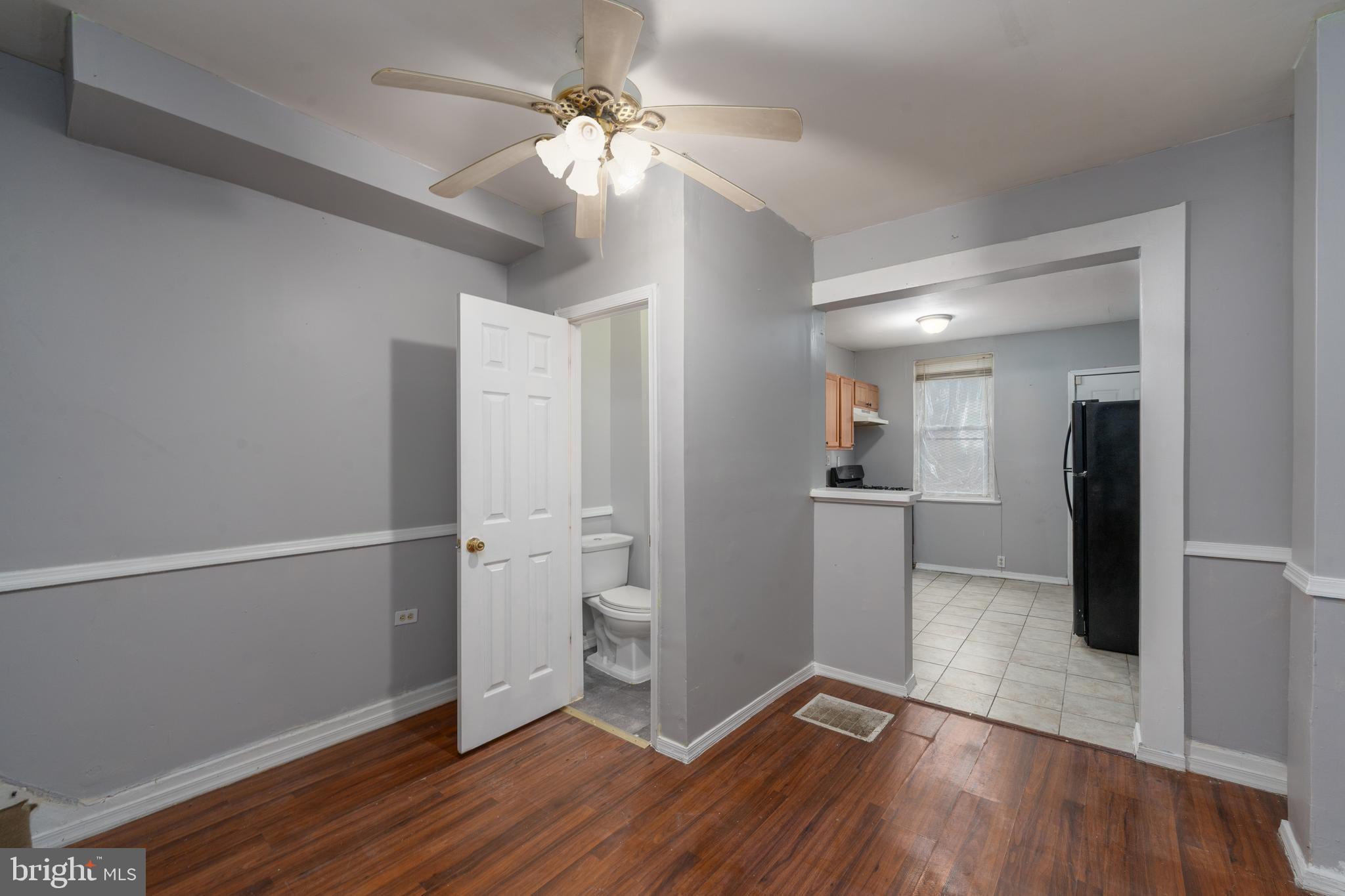 430 South Payson Street Baltimore, MD 21223 - Photo 9 of 29 a view of a kitchen with a refrigerator a ceiling fan and wooden floor