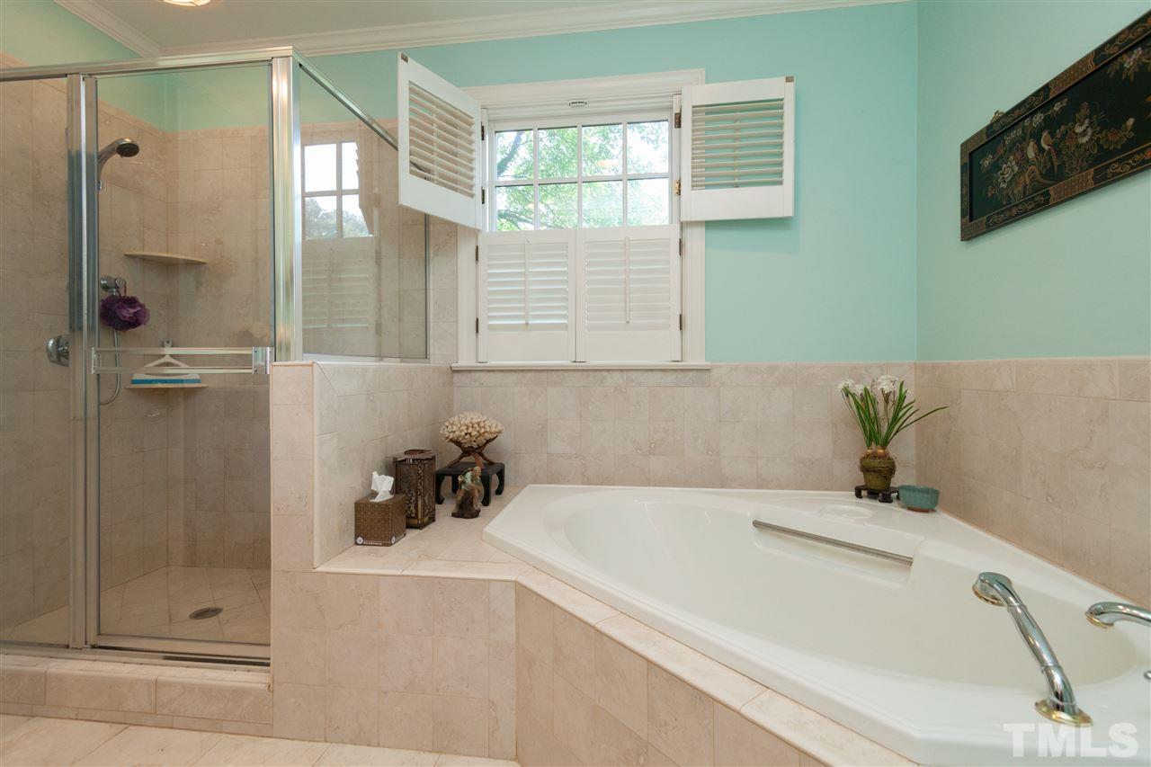 2401 Ridge Road Raleigh, NC 27612 - Photo 13 of 24 a bathroom with a tub a sink and glass door shower