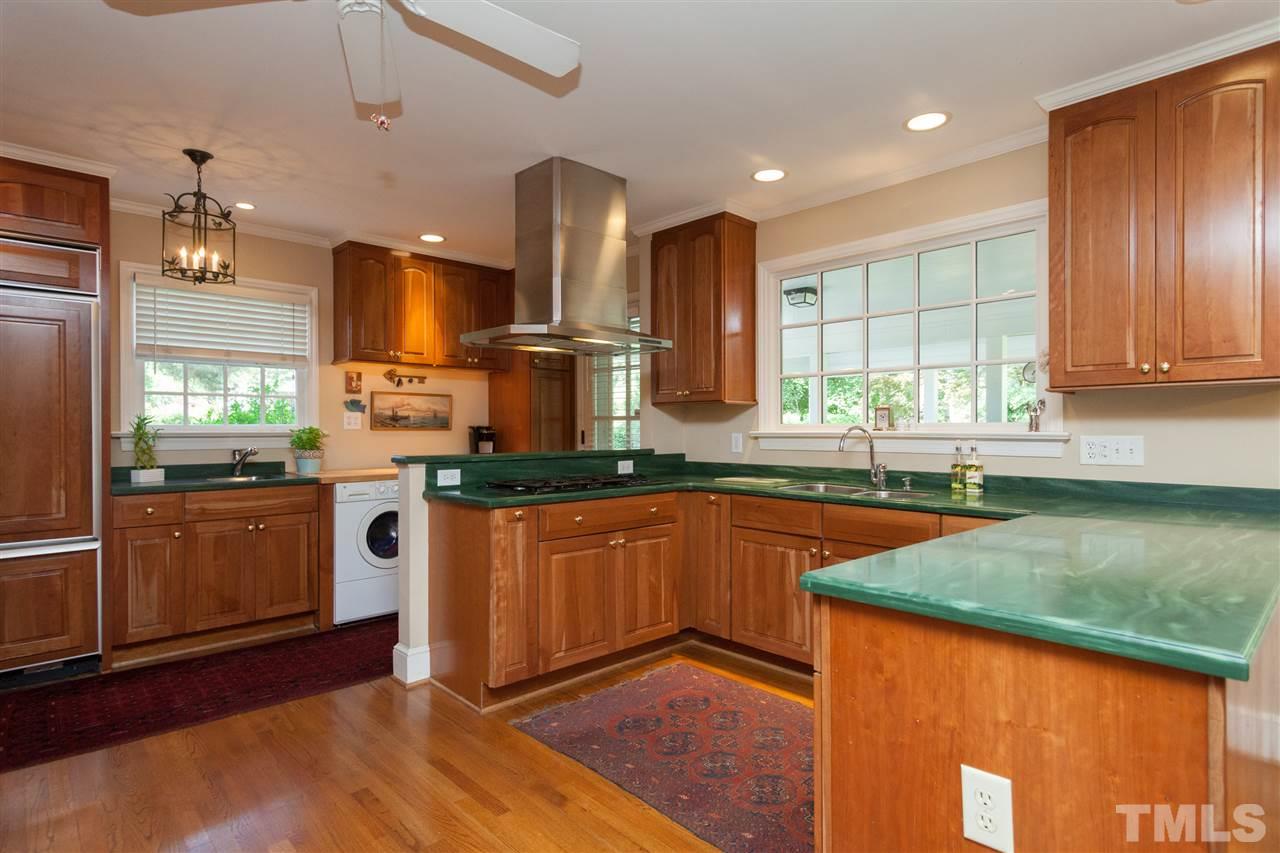 2401 Ridge Road Raleigh, NC 27612 - Photo 7 of 24 a kitchen with stainless steel appliances granite countertop wooden cabinets a sink a stove a washer dryer and a refrigerator