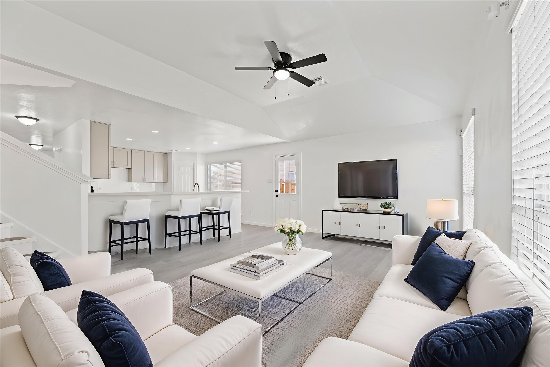 19910 Rustic Lake Lane Cypress, TX 77433 - Photo 3 of 21 Freshly installed wood look vinyl plank flooring covers this living room and is illuminated by two large windows with backyard views and seamlessly flows into the kitchen, creating a central hub for daily living and entertaining. Virtually staged so you can imagine the possibilities.