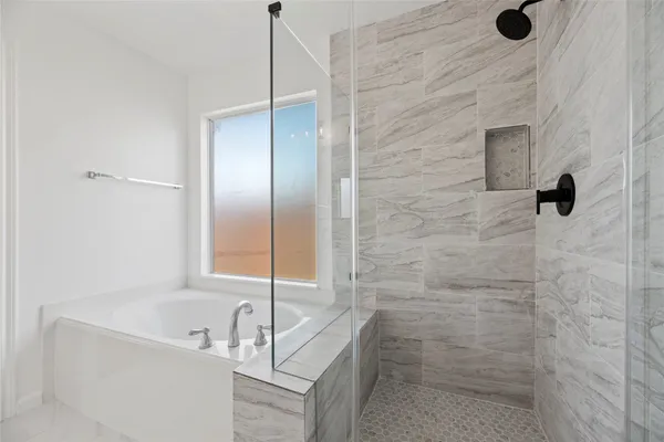 a bathroom with a tub sink a shower and mirror