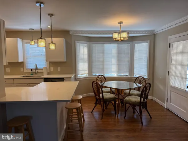 a view of a a dining room with furniture window and wooden floor