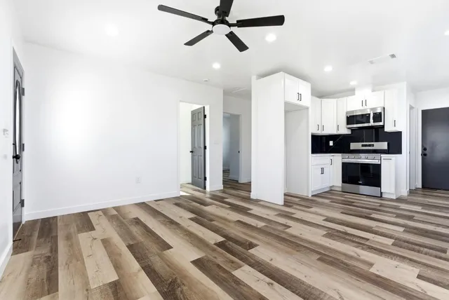 a large kitchen with a refrigerator a stove top oven and cabinets