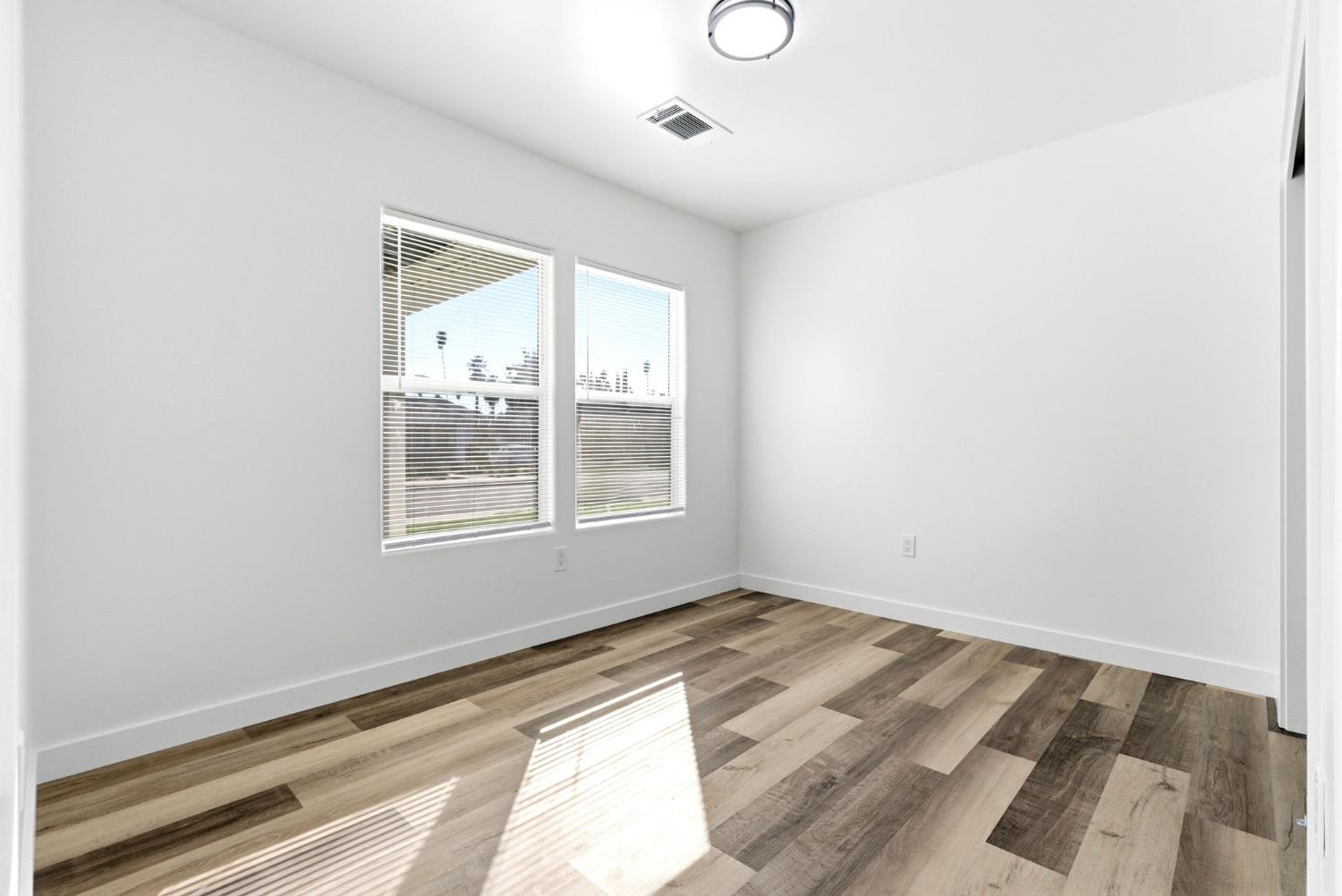 3763 East Verrue Avenue Fresno, CA 93702 - Photo 18 of 24 a view of an empty room with wooden floor and a window