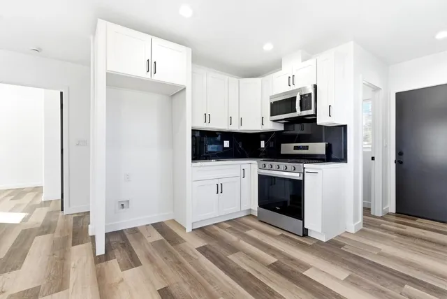 a kitchen with stainless steel appliances granite countertop a stove microwave and oven