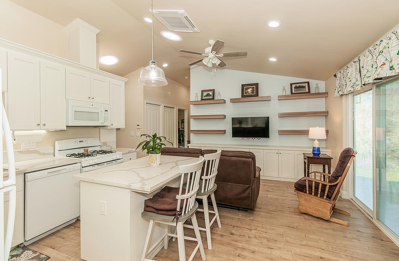 29039 Auberry Road Prather, CA 93651 - Photo 30 of 73 a kitchen with stainless steel appliances kitchen island granite countertop a stove a refrigerator a oven a white table and chairs with wooden floor