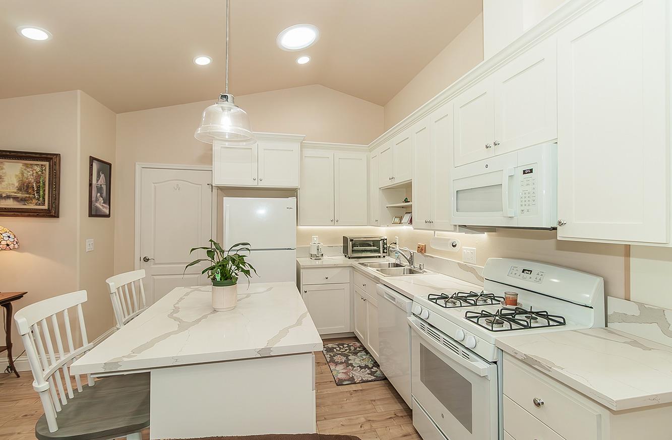 29039 Auberry Road Prather, CA 93651 - Photo 32 of 73 a kitchen that has a lot of white cabinets and stainless steel appliances