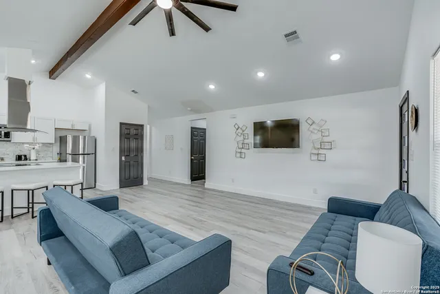 a living room with furniture and a wooden floor