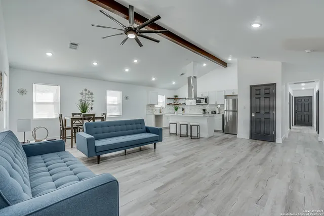 a living room with furniture and a wooden floor