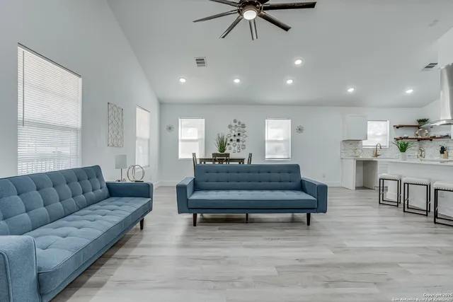 a living room with furniture and a wooden floor