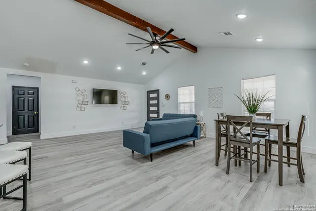 a kitchen with white cabinets and chairs