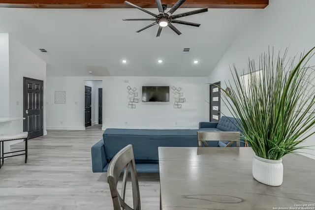 a kitchen with white cabinets stainless steel appliances and dining table