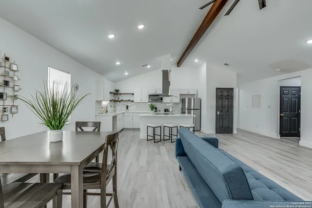 a kitchen with stainless steel appliances a sink stove refrigerator and wooden floor